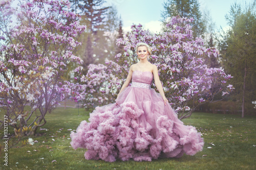 Εκτύπωση καμβά Blonde woman among blossoming trees.