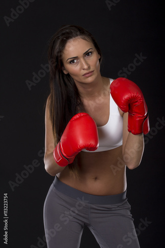 Long dark hair girl on kick box training with red gloves on her hands © pucko_ns