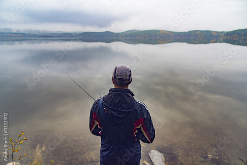 Rear view of man fishing in lake photo
