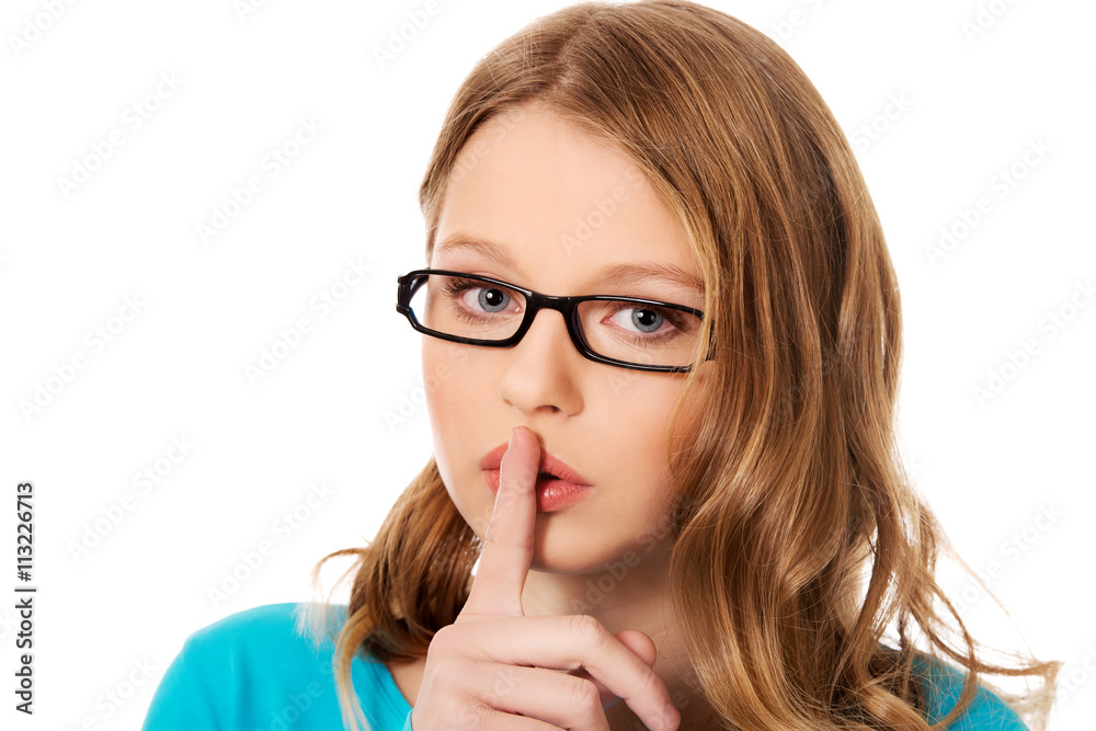 Teenage woman with finger on lips Teenage woman with finger on lips