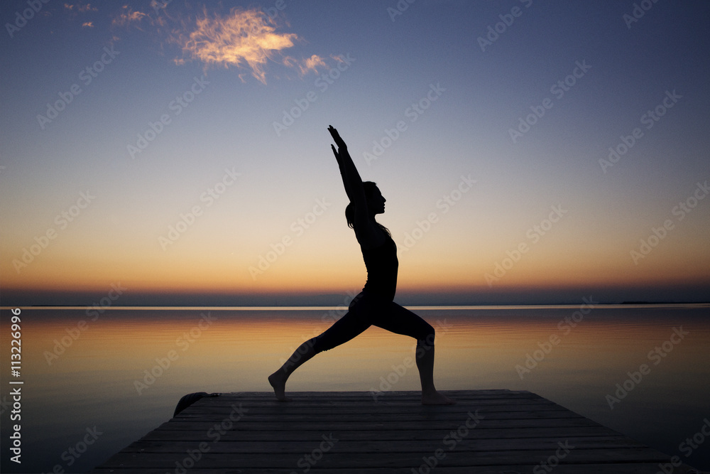 Woman at seaside doing yoga at sunset Woman at seaside doing yoga at sunset