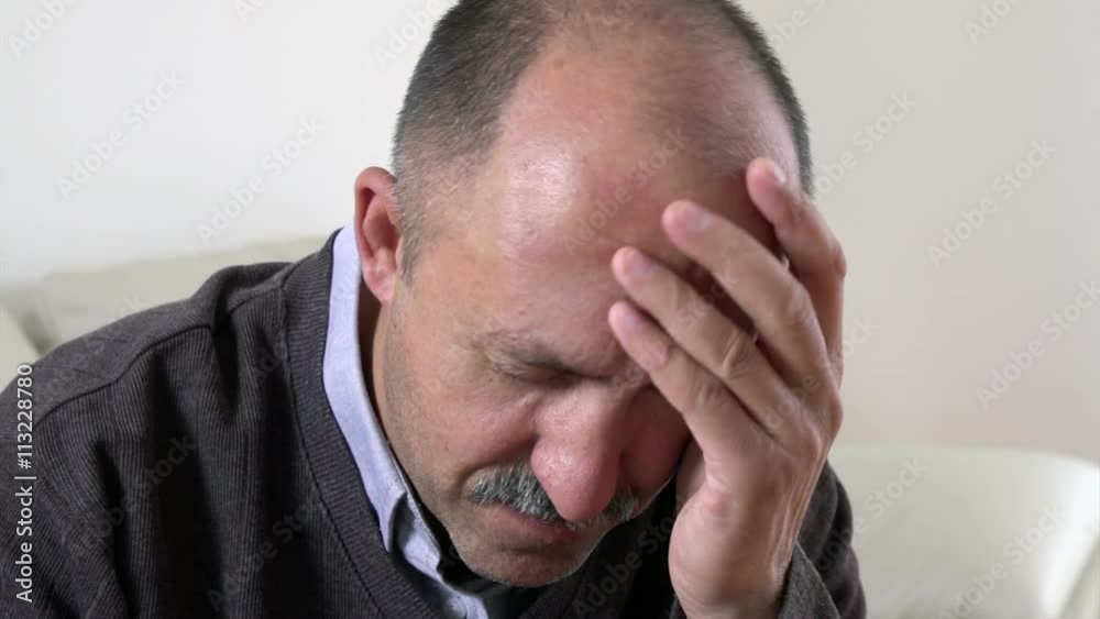 Tired unhappy man with headache migraine at home. Tired unhappy man with headache migraine at home.