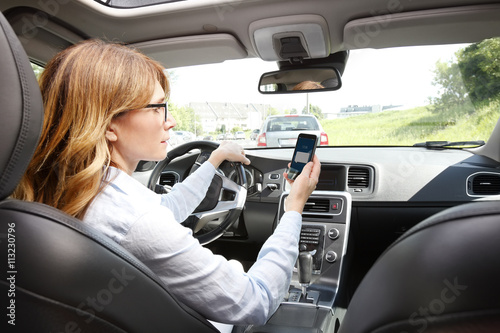 Принти на полотні Reckless driver using her mobile phone while driving car