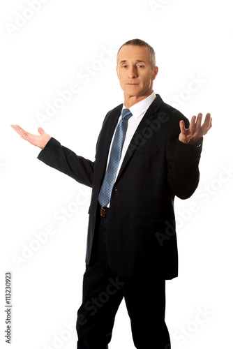 Businessman with open hands in undecided gesture