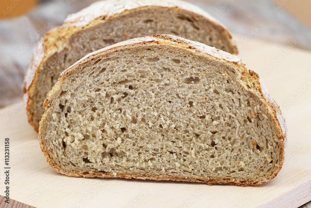 Half a rustic bread on wooden board
Half a rustic bread on wooden board