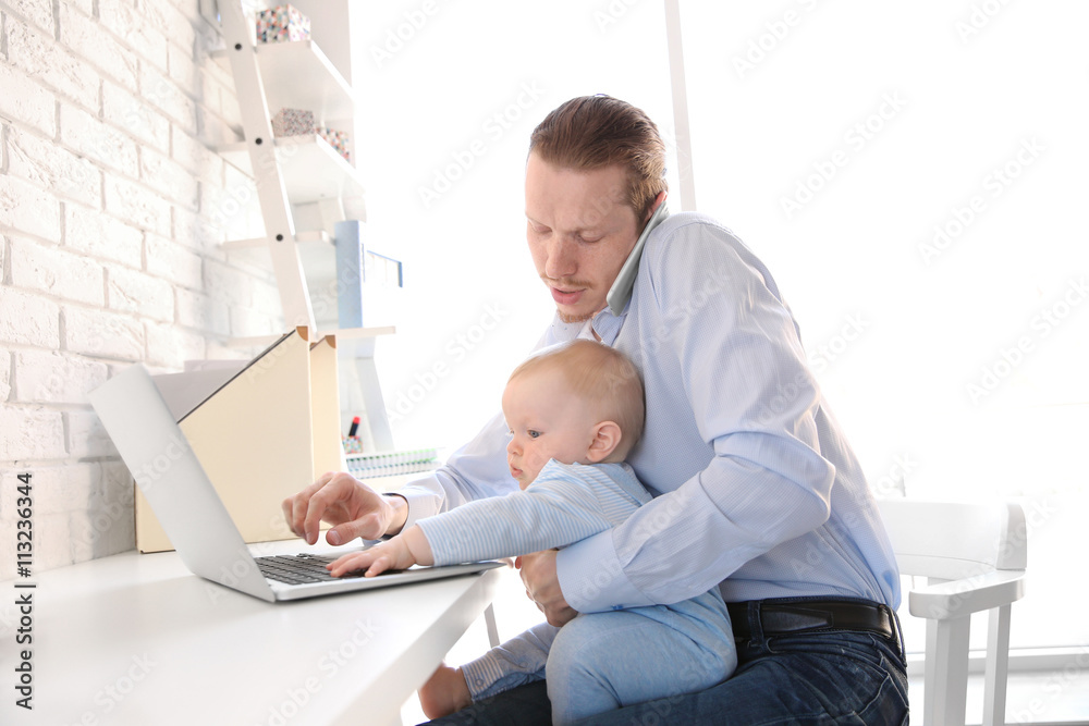 © Africa Studio - Young father with his little son working at home © Africa Studio - Young father with his little son working at home