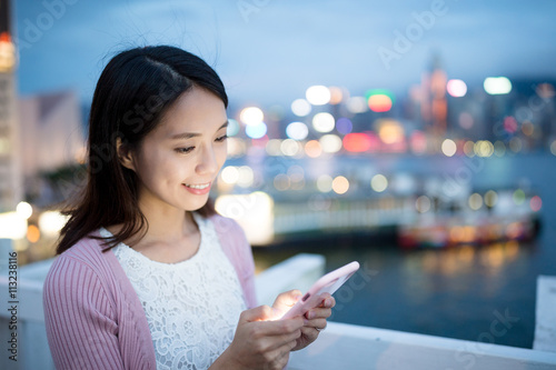 Asian woman sending sms on mobile phone