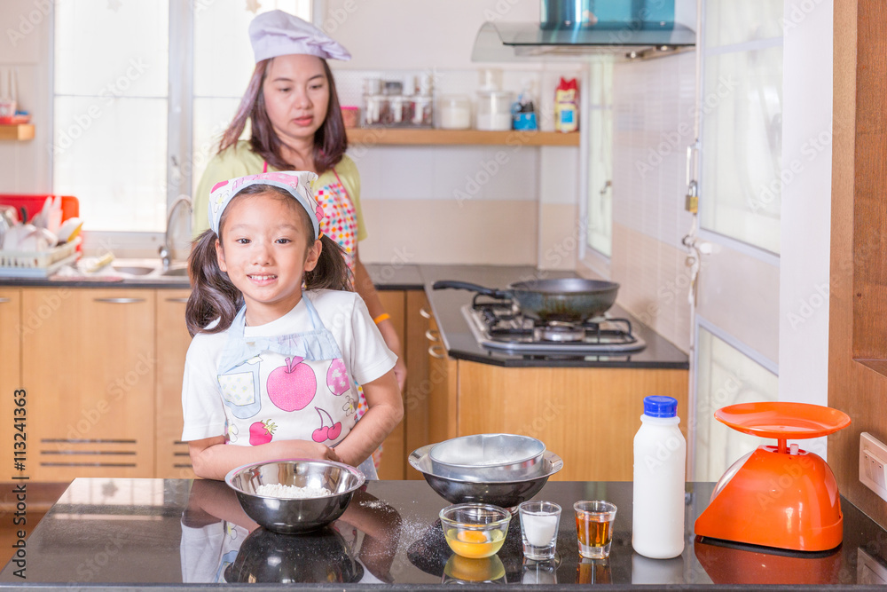 Asian mother and daughter enjoy making pancake in kitchen at home Asian mother and daughter enjoy making pancake in kitchen at home