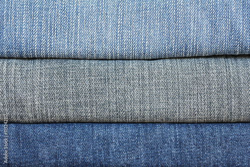 Closeup denim jeans texture. Stitched textured blue denim jeans background. Old grunge vintage denim jeans. Denim jeans of fashion design. Dark edged.