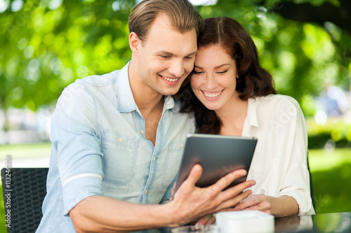 Couple using a tablet at the park