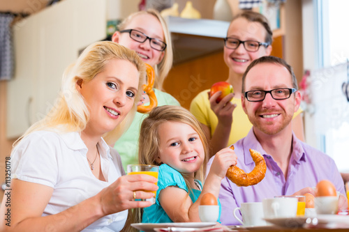 Familie isst Frühstück gemeinsam in Küche © Kzenon