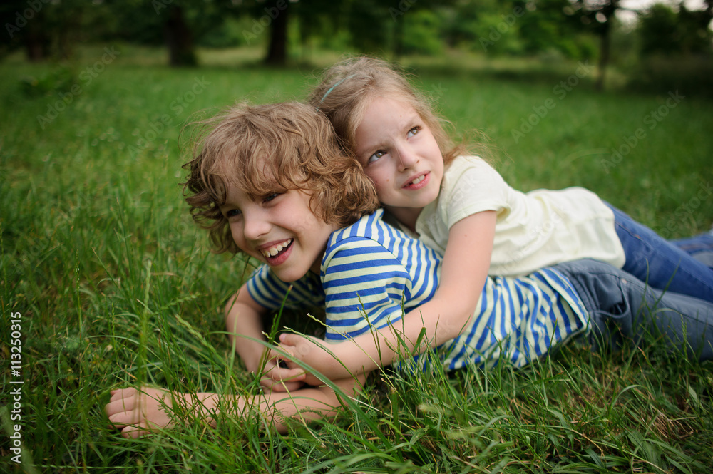 Bbrother and sister play on a green lawn Bbrother and sister play on a green lawn
