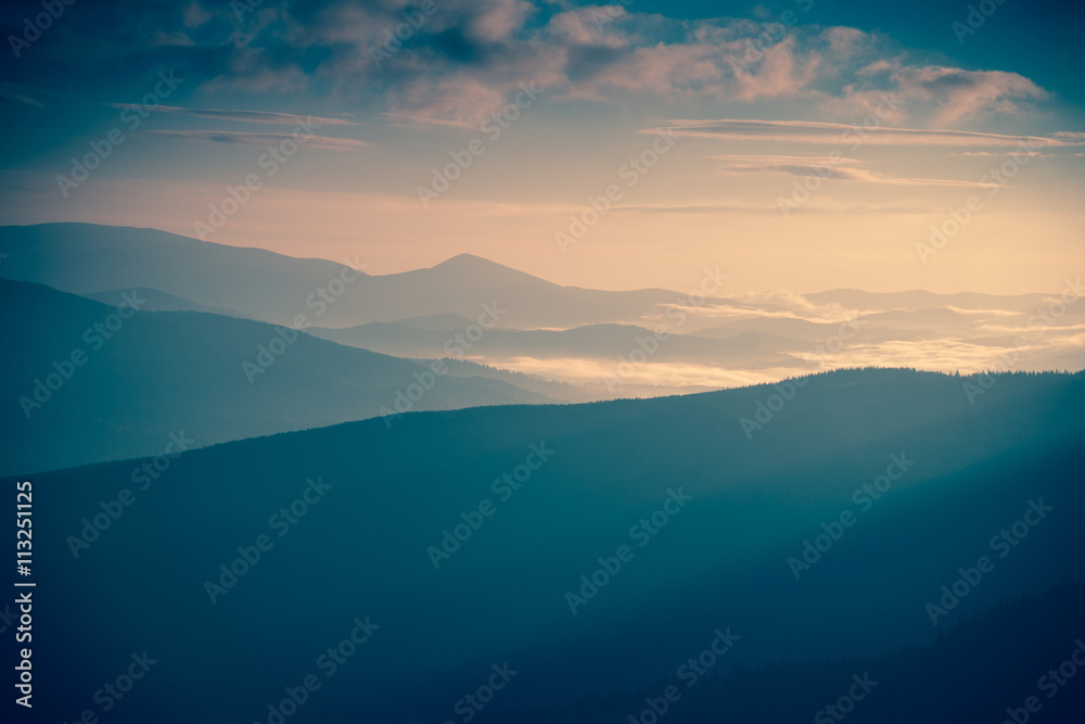 Sunrise landscape of foggy and cloudy mountain valley. Instagram toning.