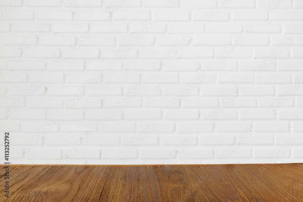 Wooden table with blurred white birck wall on the background, can be used for product montage Wooden table with blurred white birck wall on the background, can be used for product montage