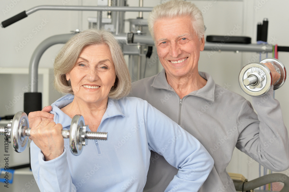 senior couple exercising in gym senior couple exercising in gym