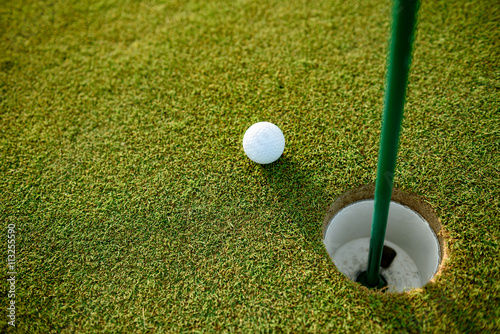 Close up of golf ball next to hole
