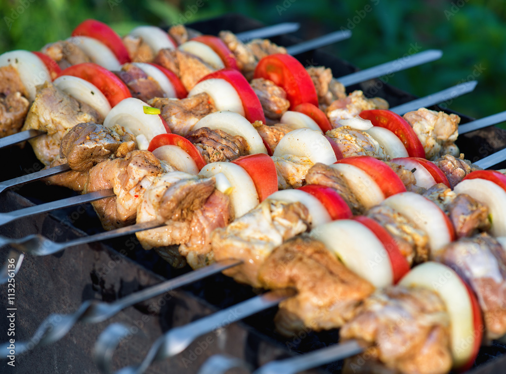Barbecue with delicious grilled meat on grill. Pork meat pieces being fried on a charcoal grill.