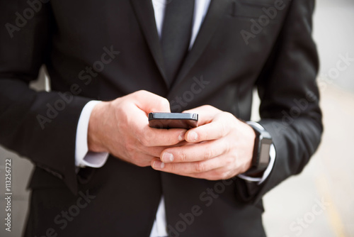 Pleasant man holding smart phone