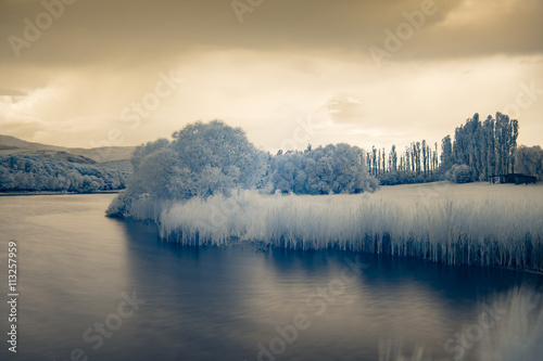 Infrared view at lake s surface under the stormy clouds