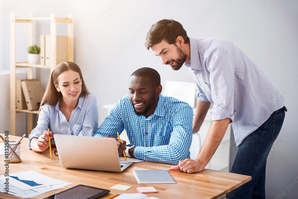 Positive smiling colleagues working on the project Positive smiling colleagues working on the project
