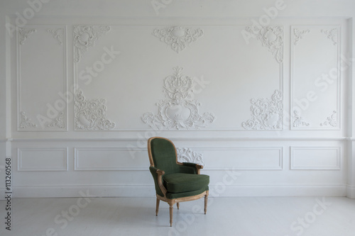 vintage luxury green armchair in white room over wall design bas-relief stucco mouldings roccoco elements photo