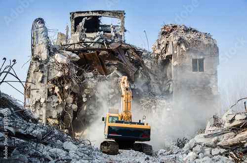 Excavator working at the demolition of an old industrial buildin