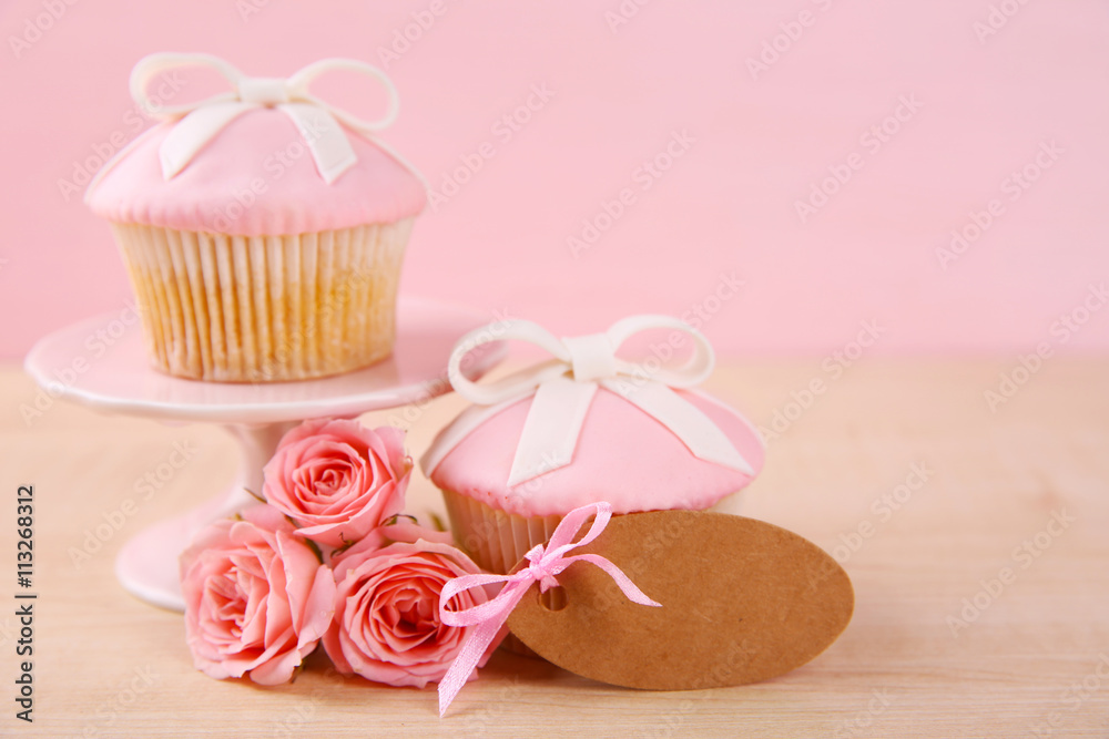Mother Day concept. Roses with cupcake on pink background