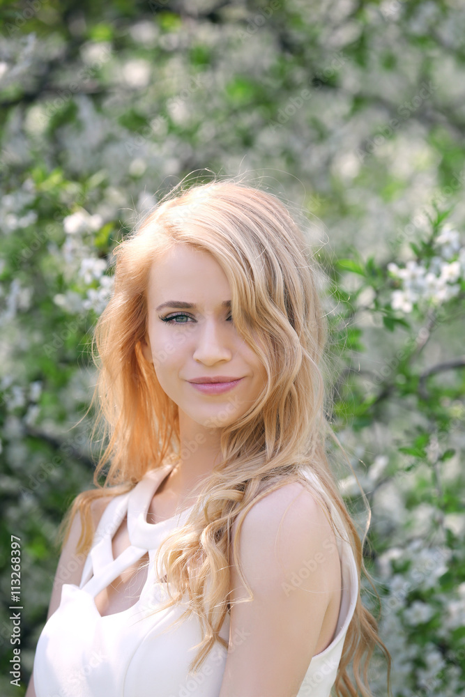 Young beautiful woman on blooming tree background