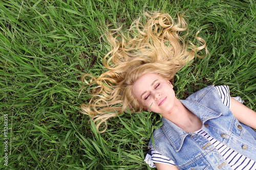 Young beautiful woman on green grass