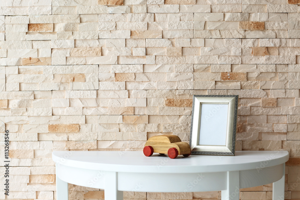 Baby toy and frame on brick wall background Baby toy and frame on brick wall background