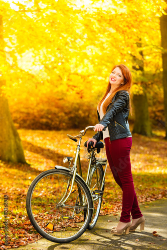 Beauty girl relaxing in autumn park with bicycle, outdoor © Voyagerix
