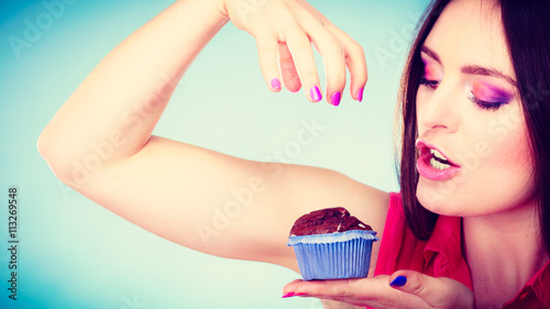 Smiling woman holds chocolate cake in hand