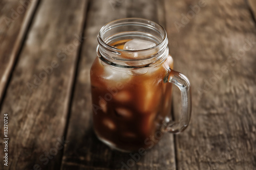 Jar of ice coffee on wooden table