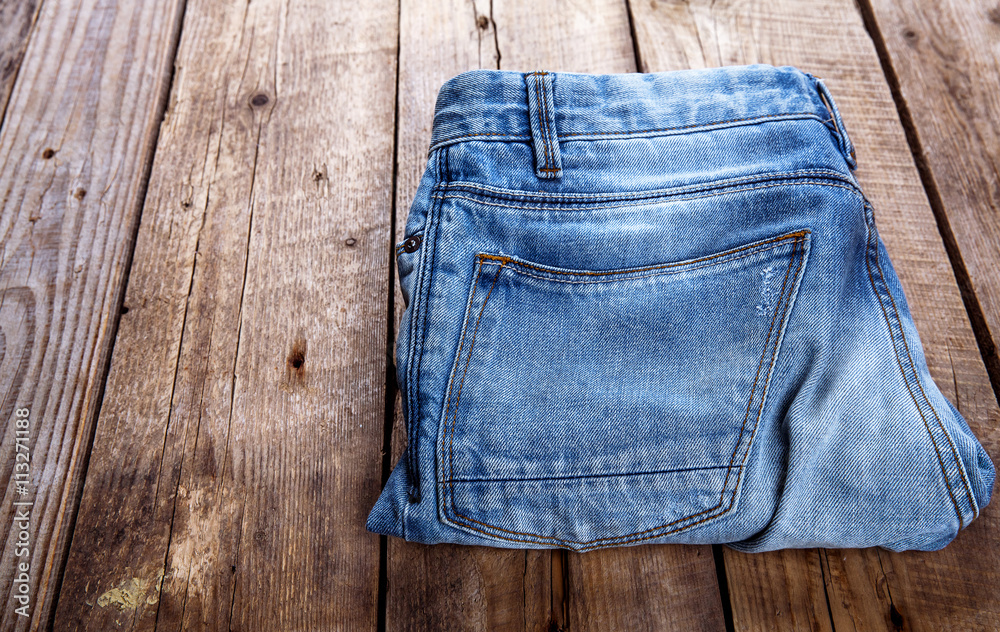 jeans stacked on a wooden background jeans stacked on a wooden background