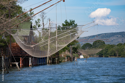 Fisherman house and net on the river in Montenegro