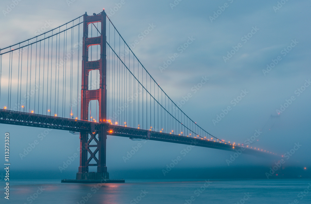 scenic view of Golden gate in the in the dusk with lighting and fog.