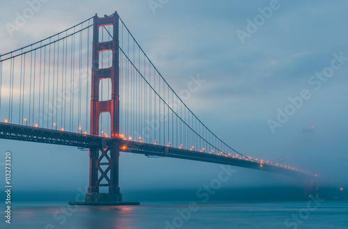 scenic view of Golden gate in the in the dusk with lighting and fog.