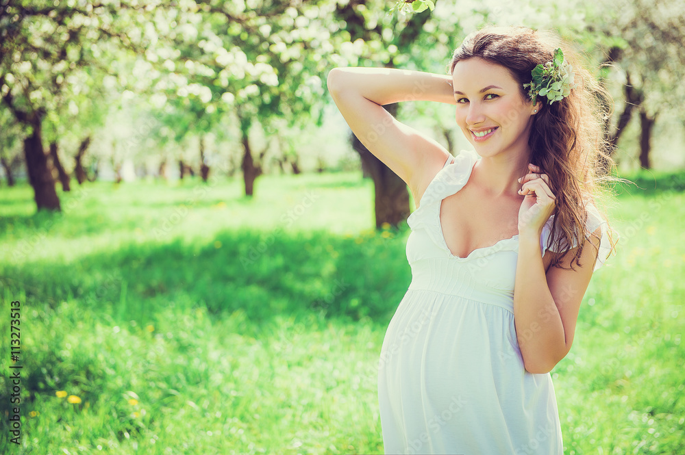 Pregnant woman in the apple orchard
