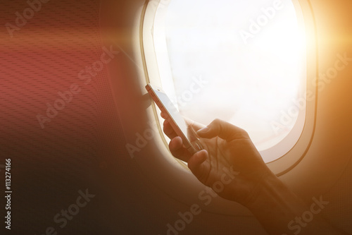holding mobile phone with flight mode in the airplane photo