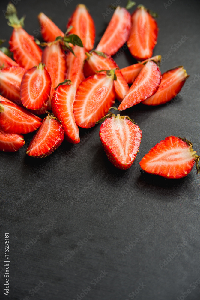 strawberries cut into pieces on black background with copyspace strawberries cut into pieces on black background with copyspace