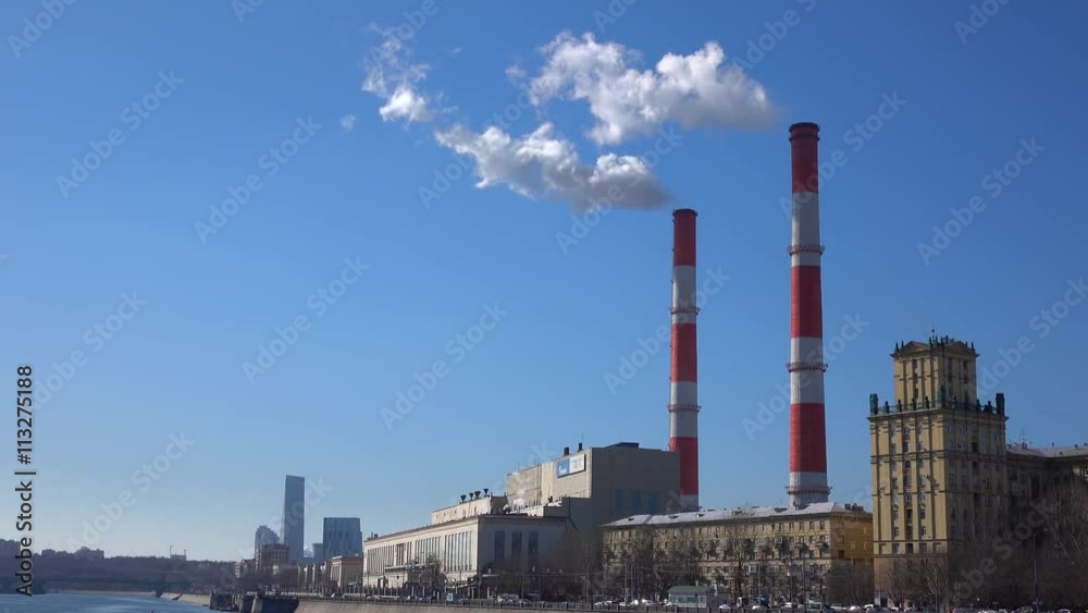 Heat electric plant and smoke from smoke stacks against blue sunny sky. 4K shot Heat electric plant and smoke from smoke stacks against blue sunny sky. 4K shot