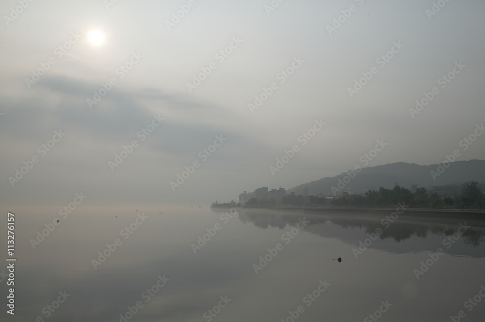朝靄の湖畔の街並み