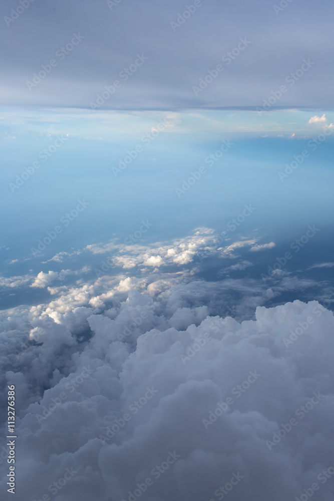 Aerial view on clouds and blue sky from airplane window