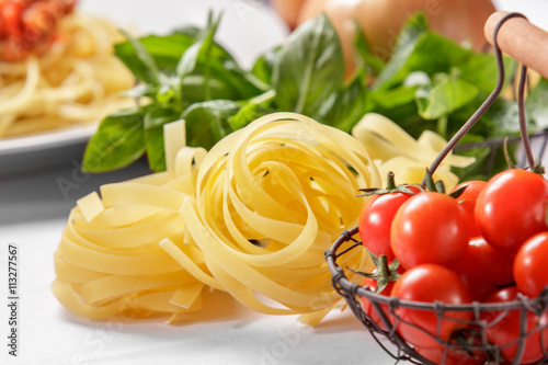 raw italian tagliatelle pasta and cherry tomatoes
