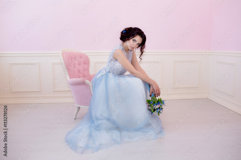 Young beautiful bride sitting in a pink chair. The Studio is all pink. Young beautiful bride sitting in a pink chair. The Studio is all pink.