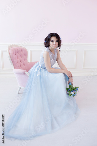 Young beautiful bride sitting in a pink chair. The Studio is all pink. © tatiana1987