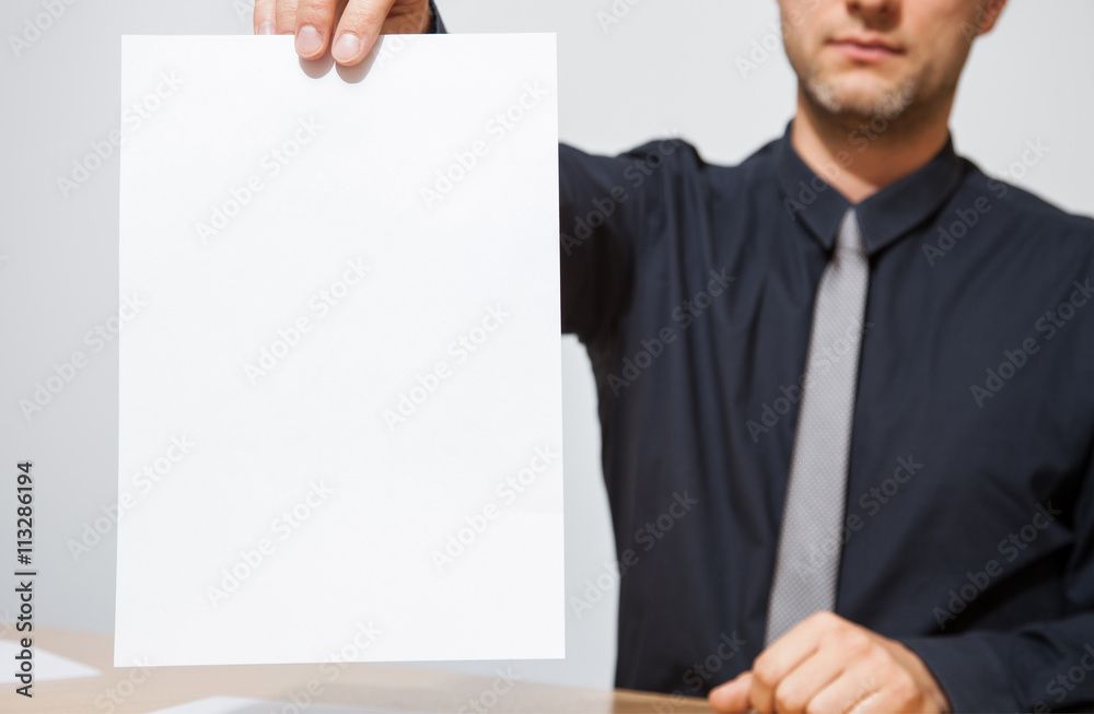 Businessman holding an empty sheet of paper