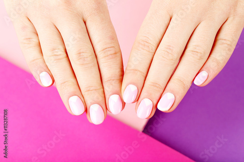 Female hand with manicure on a colorful background