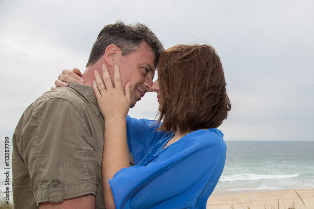 Attractive couple embracing on the beach on a sunny day Attractive couple embracing on the beach on a sunny day