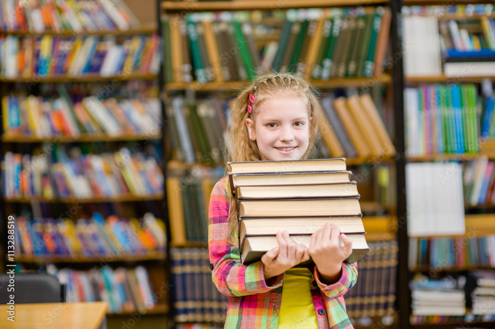 Teen girl holding pile books in the library Teen girl holding pile books in the library